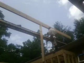 Carpenter setting a ridge beam over a new addition frame — Ice Dam Removal by Roofing Brothers in Ceresco