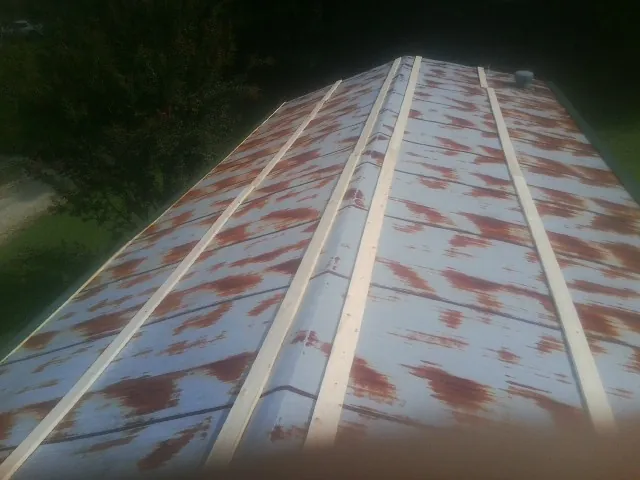 Rusted metal roof panels with new wood purlins before replacement — Storm Damage Roof Repair in Ceresco by Roofing Brothers