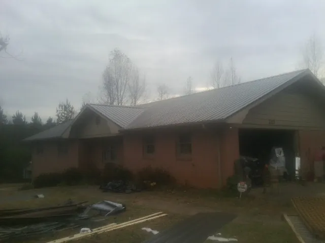 Gray metal roof on a stucco house with an attached garage in Ceresco