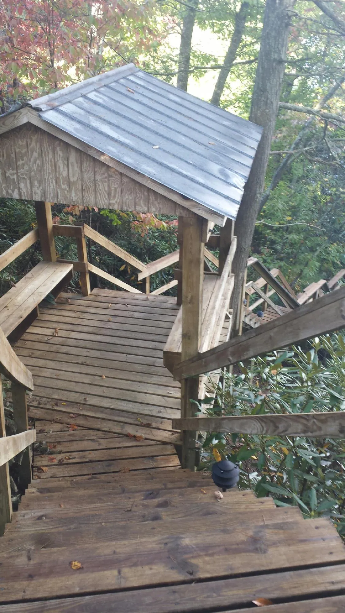 Metal roofed shelter over wooden steps on a wooded walkway — Skylight Repair & Installation work by our crew in Ceresco